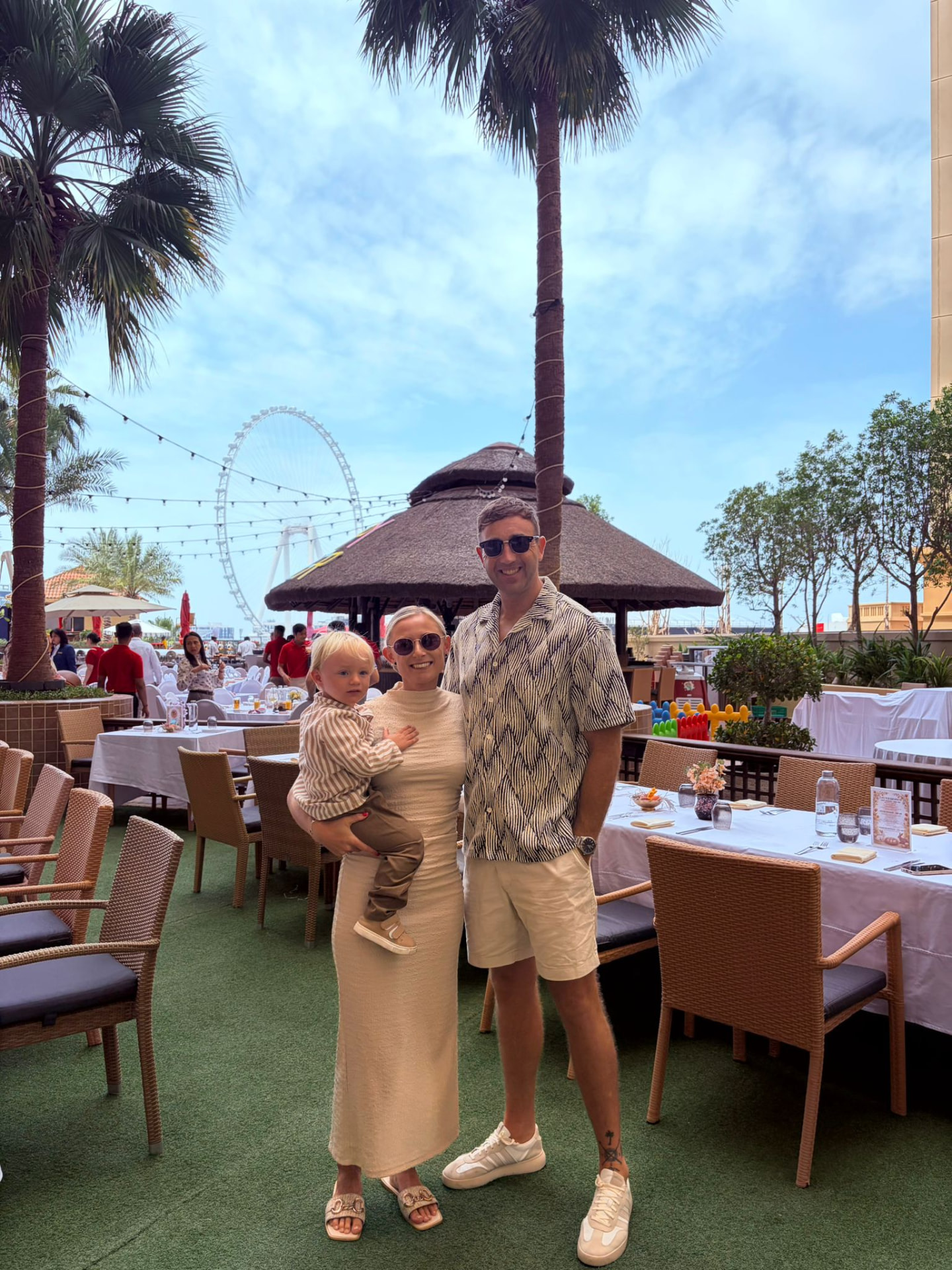Mollie, her partner and Noah enjoying a family brunch in Dubai with Ain Dubai in the background