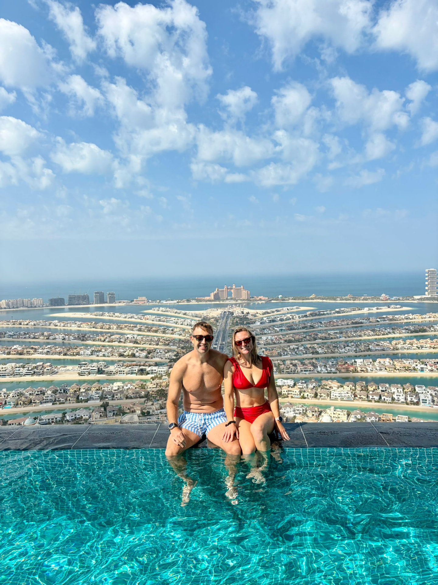 Mollie and her partner at a rooftop infinity pool overlooking the Palm Jumeirah